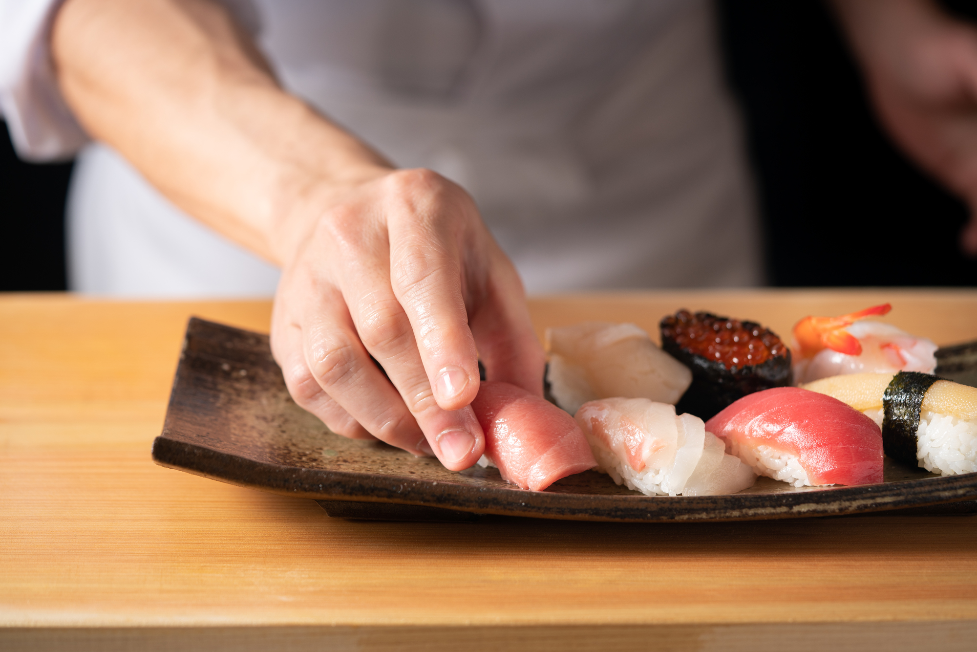 職人が握る鮨の手元、檜のカウンター
